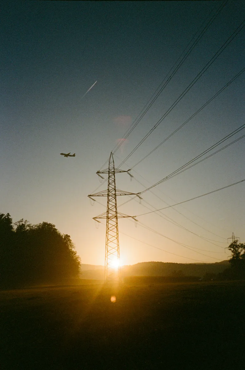 Electricity transmission pylon silhouetted against an evening sky